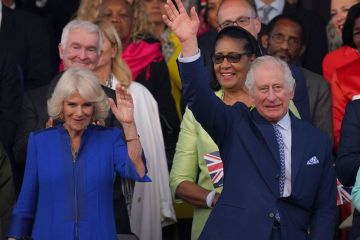 King Charles & Queen Camilla beam with delight as they watch coronation bash