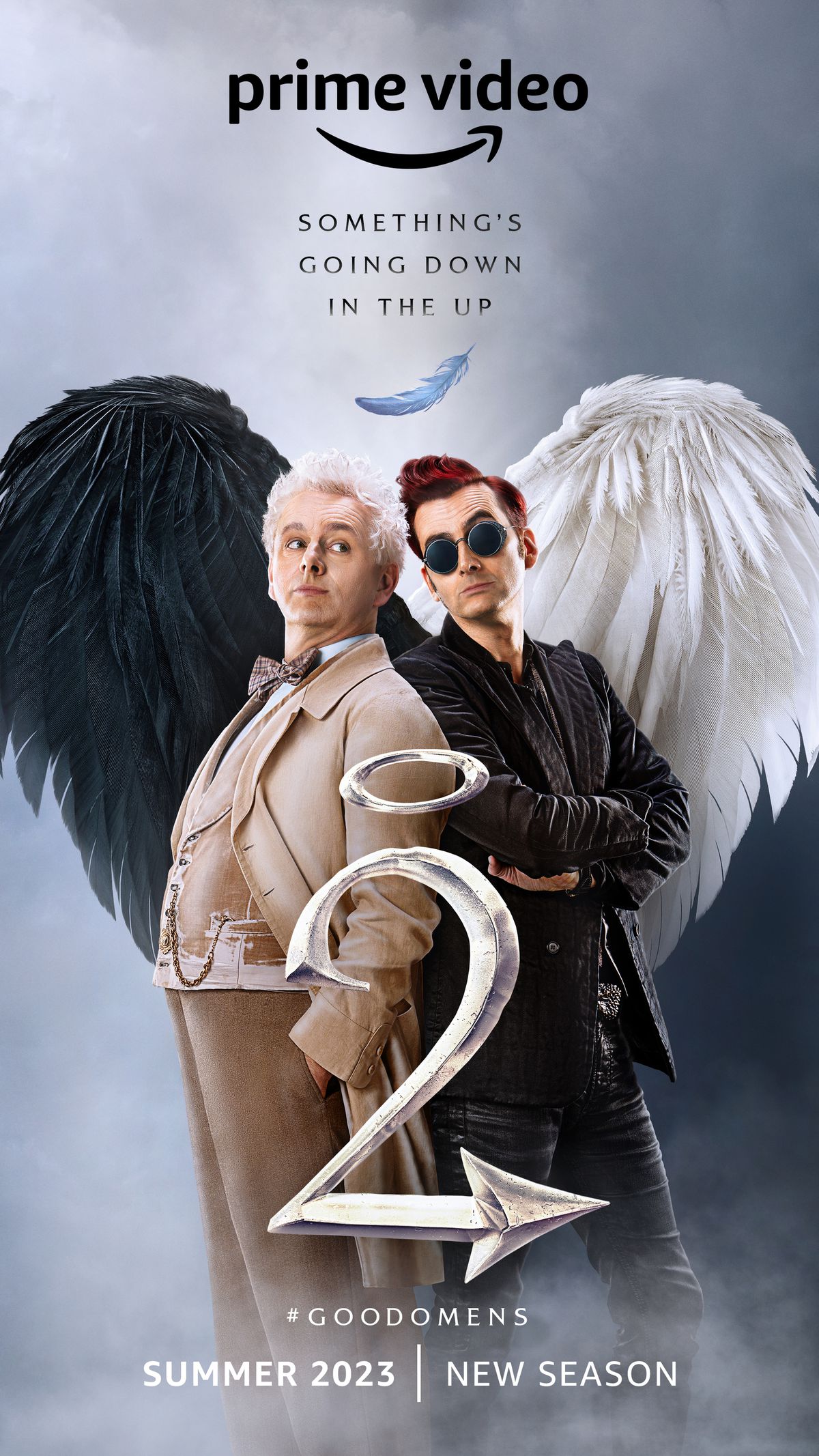 A poster for Good Omens season 2, featuring Michael Sheen as Aziraphale and David Tennant as Crowley, standing back-to-back with their wings forming a heart. 