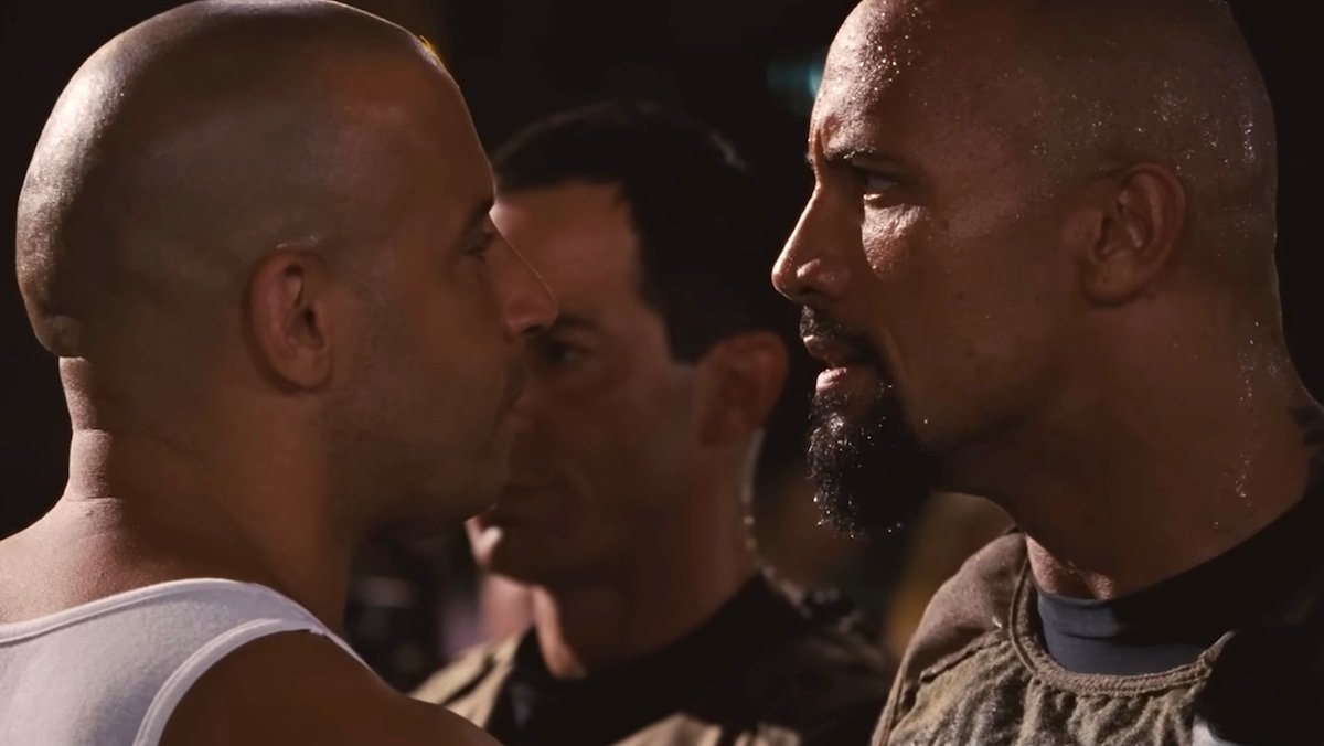 Vin Diesel and Dwayne Johnson stare at each other from up-close in Fast Five
