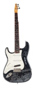 A black and white Fender Stratocaster guitar bearing autographs and inscriptions
