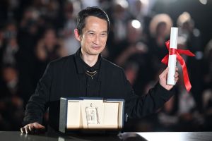 Vietnamese-French director Tran Anh Hung poses with the trophy after he won the Best Director prize for the film "La Passion de Dodin Bouffant" (The Pot-au-Feu)