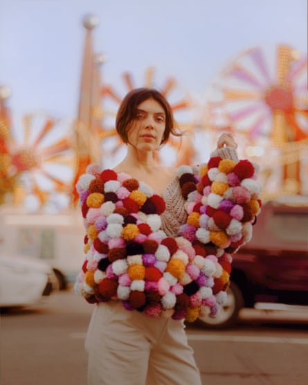 Julie Byrne holding a huge armful of coloured pompoms.