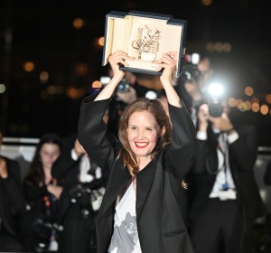 French director Justine Triet lifts her trophy after winning the Palme d'Or for the film Anatomie d'une Chute (Anatomy of a Fall)