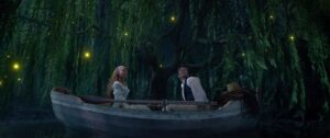Ariel and Eric sitting on opposite ends of a canoe in a blue lagoon.