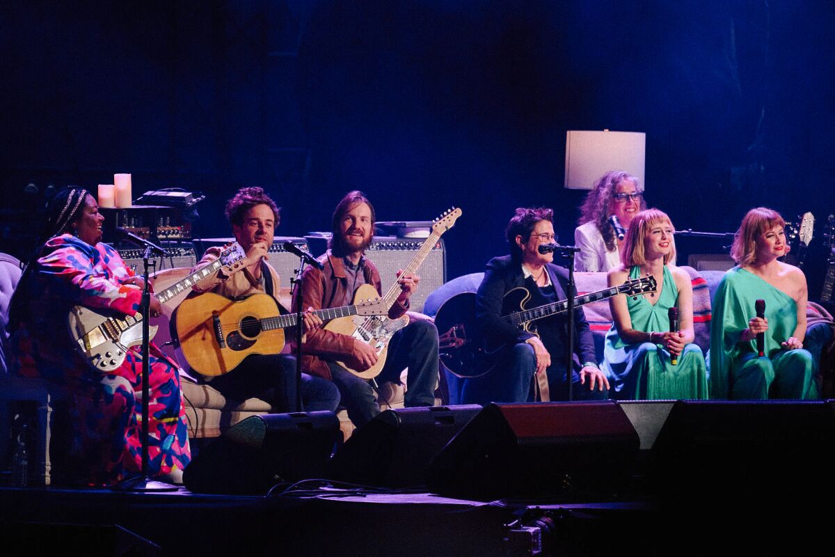 Several artists dubbed the Joni Jammers sit on stage.