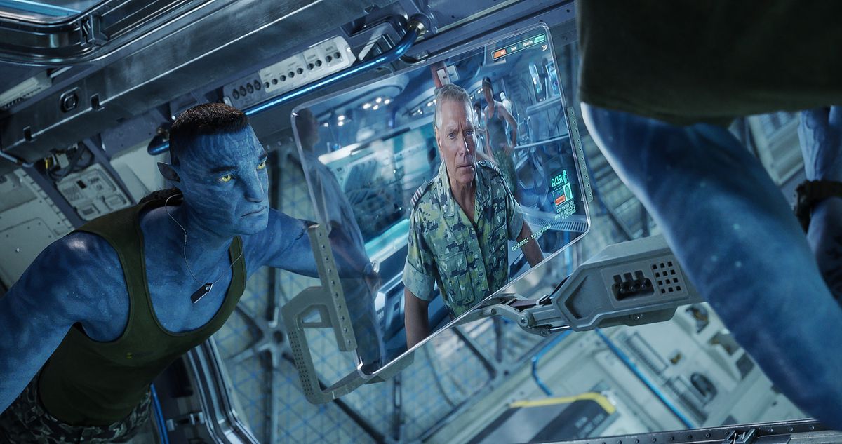 The resurrected Na’vi version of Col. Quaritch (Stephen Lang) watches a video featuring instructions from the original human version of himself in a lab in Avatar: The Way of Water.