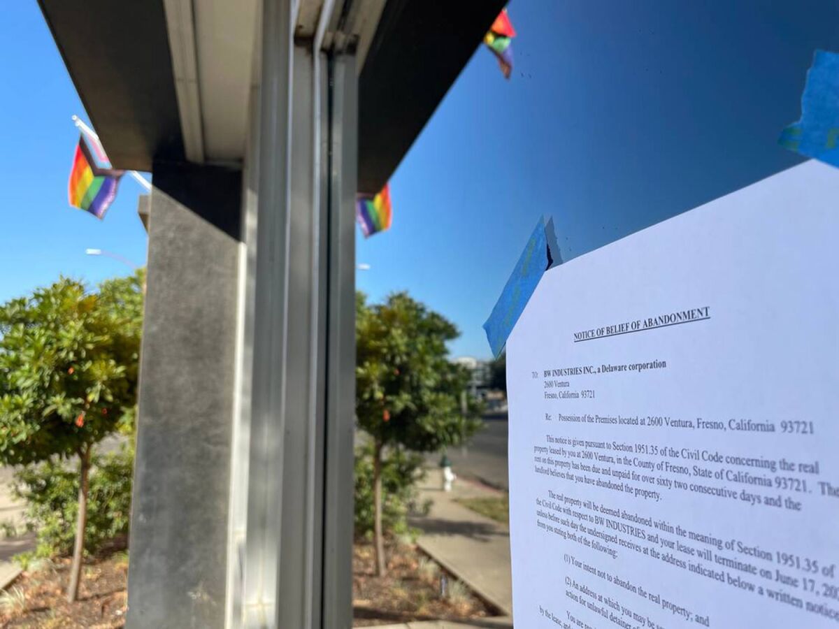 Legal "notices of belief of abandonment" sign is taped to a glass of a building