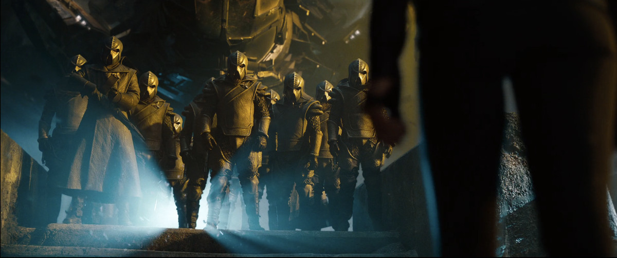 The Klingons greeting Uhura (Zoe Saldana) by standing and looking imposing with helmets on in a still from Star Trek into Darkness