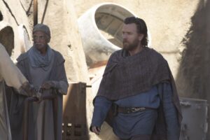 A bearded Obi-Wan Kenobi (Ewan McGregor), walks through a town in a scene from "Obi-Wan Kenobi."