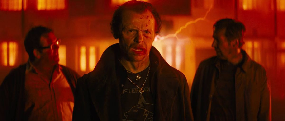 Three haggard looking men (L-R Nick Frost, Simon Pegg, Eddie Marsan) walking away from a building glowing with red lightning in The World’s End.