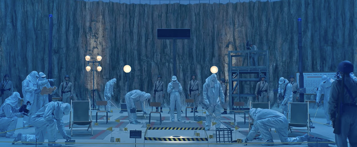 A group of government agents in white full-body Hazmat suits scours the asteroid crater where the alien landed in Wes Anderson’s Asteroid City