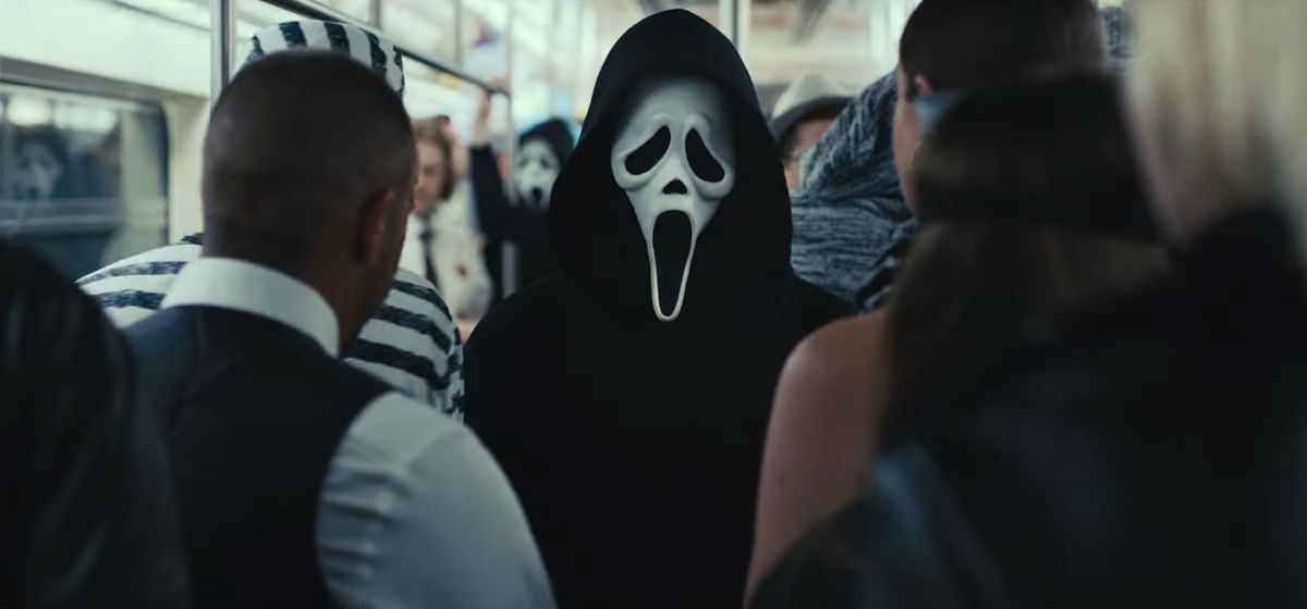 A person wearing a Ghostface mask stands on a crowded New York City subway car in a still from Scream VI.
