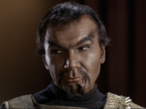 A close-up of Kor (John Colicos) in his Klingon makeup, which includes brownface, Spock-like eyebrows, and a Fu Manchu mustache, in a still from Star Trek the Original Series