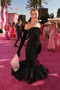Margot Robbie dons a sequined black gown on the pink carpet.