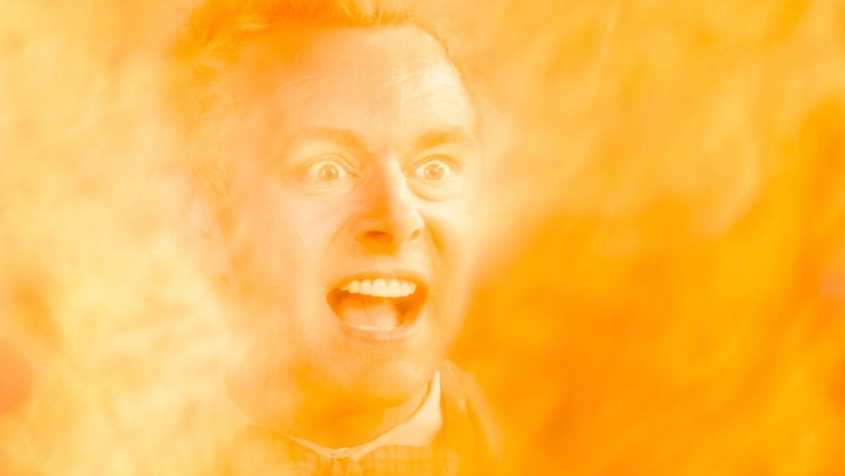 Michael Sheen screams while bathed in flame in Good Omens