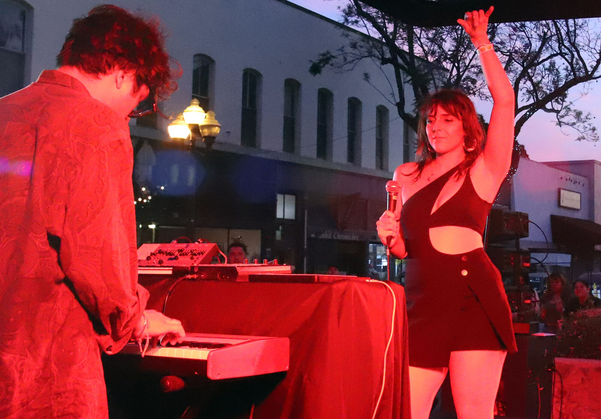 A woman dancing and a man playing keyboard.