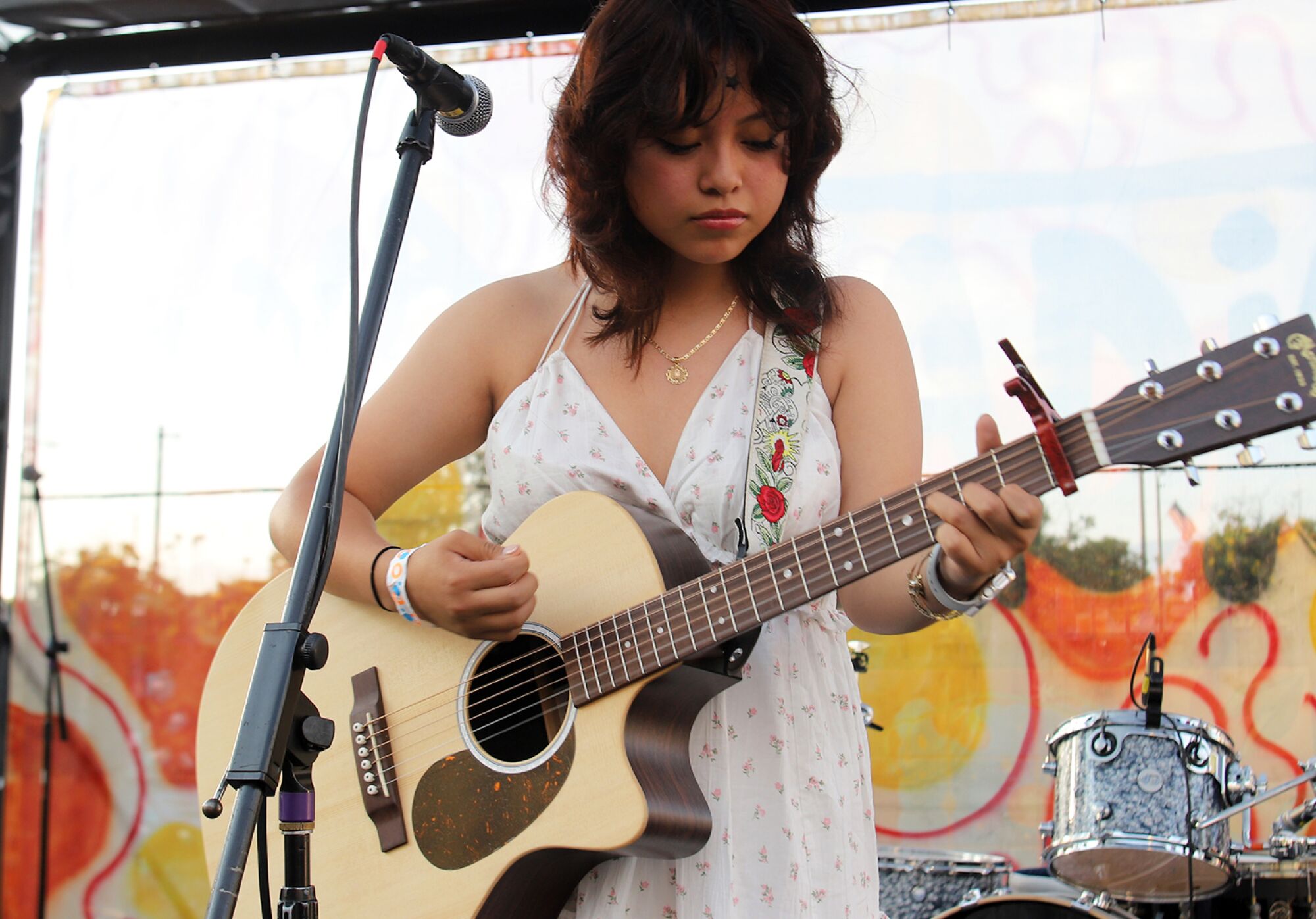 A woman plays an acoustic guitar