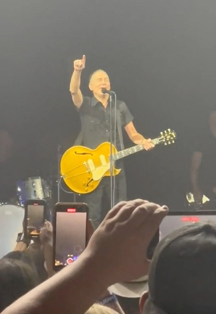 Bryan Adams with guitar singing.