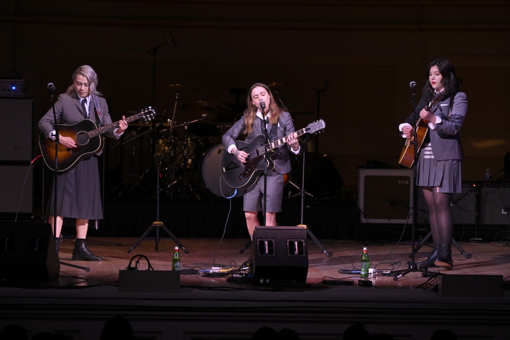 Phoebe Bridgers, Julien Baker, and Lucy Dacus of Boygenuis on stage performing, 