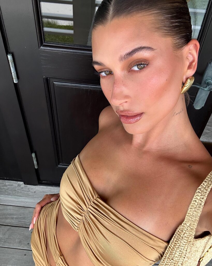 Hailey Bieber showed off her tiny waist in a tight gold dress as her close friend Kylie Jenner praises the star's new photos