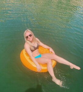 Jade Carey sits on a floatie while wearing a mismatched bikini.