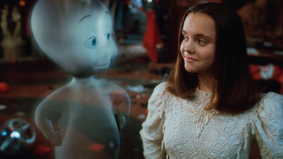 A CGI ghost standing next to a dark-haired young teenager. They are grinning at each other. 
