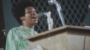 A woman sings into a microphone at a podium