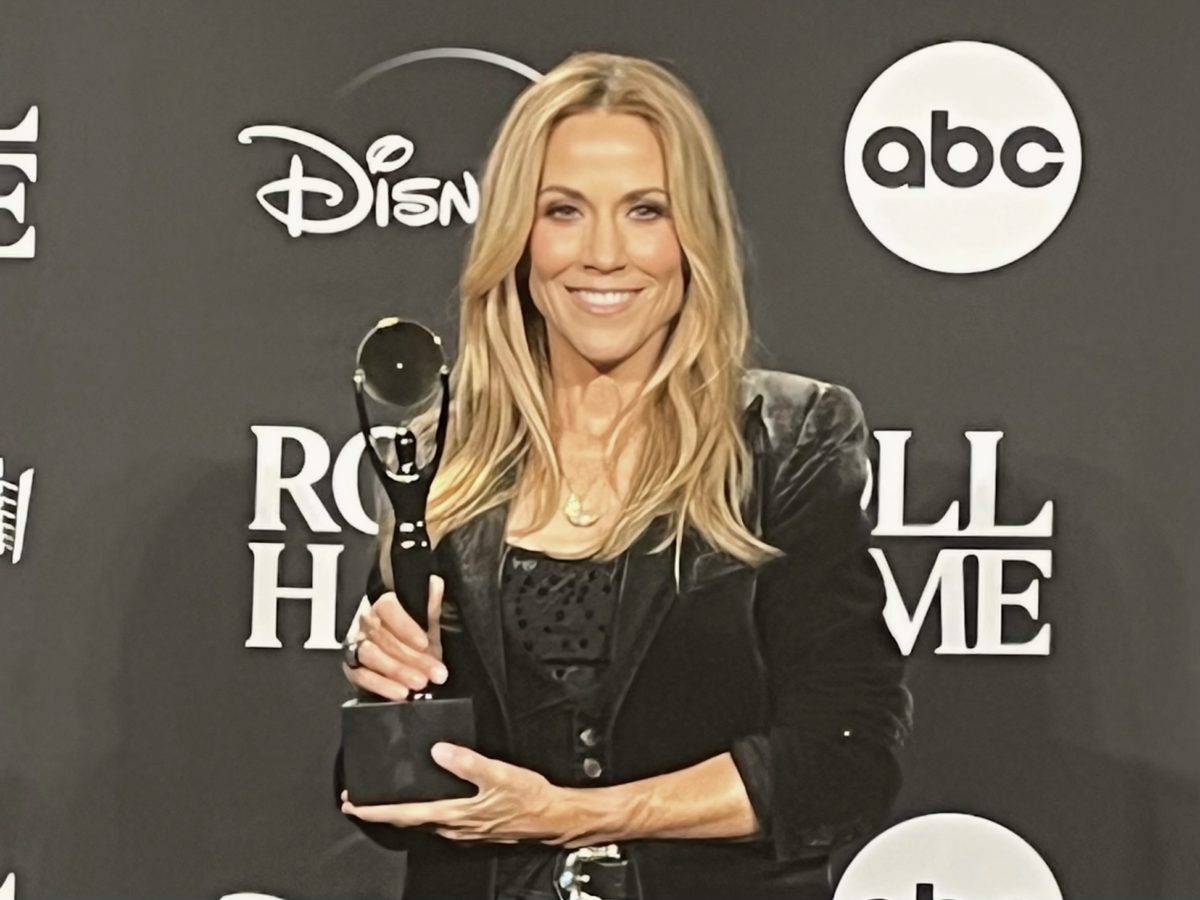 Sheryl Crow posing with her trophy at the Rock and Roll Hall of Fame