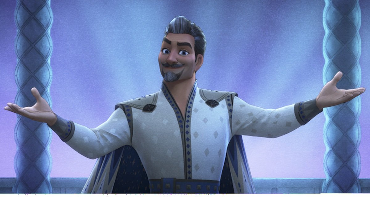A silver-haired king with a beard wearing white holds out his arms in Disney's animated Wish