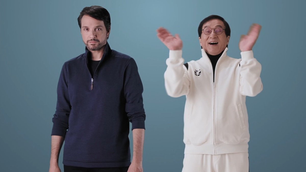 A stern Ralph Macchio and a joyful Jackie Chan with his arms up in announcement for new Karate Kid movie