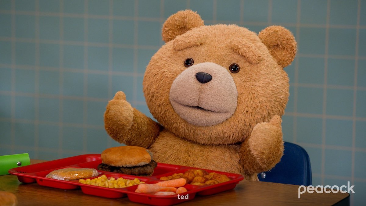 Ted giving thumbs up in front of a tray of food in a cafeteria