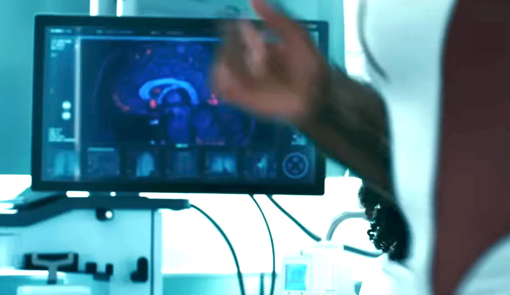 A computer screen in the background of a shot from The Marvels features the X-Men logo in the bottom right.
