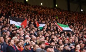Fans at Anfield hold up flags in support of Palestine on 21 October.