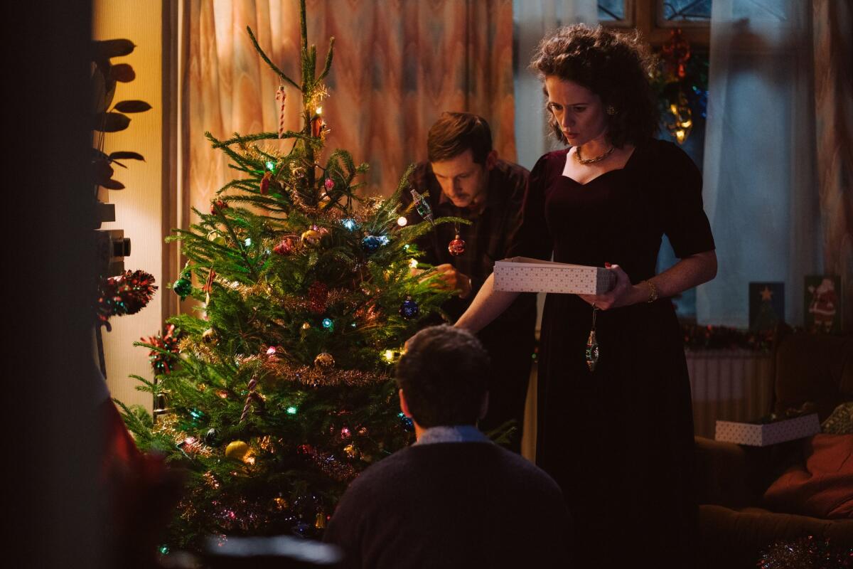 A family decorates a Christmas tree.