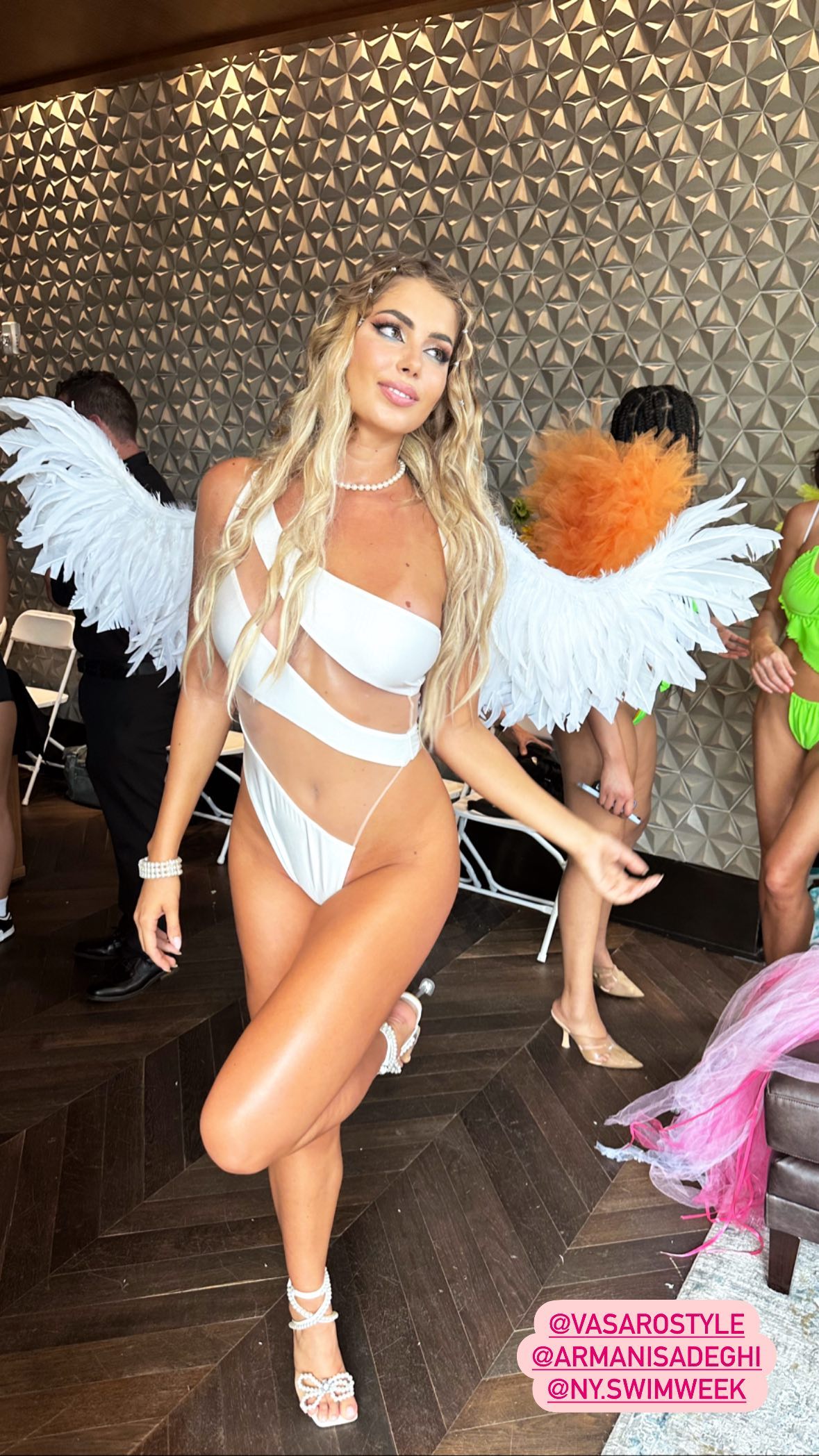 She wowed in a white one-piece complete with eye-catching white feathered wings