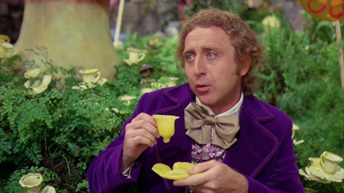 Gene Wilder’s Wonka takes a sip out of a waxy-looking yellow teacup, right before taking a bite out of it
