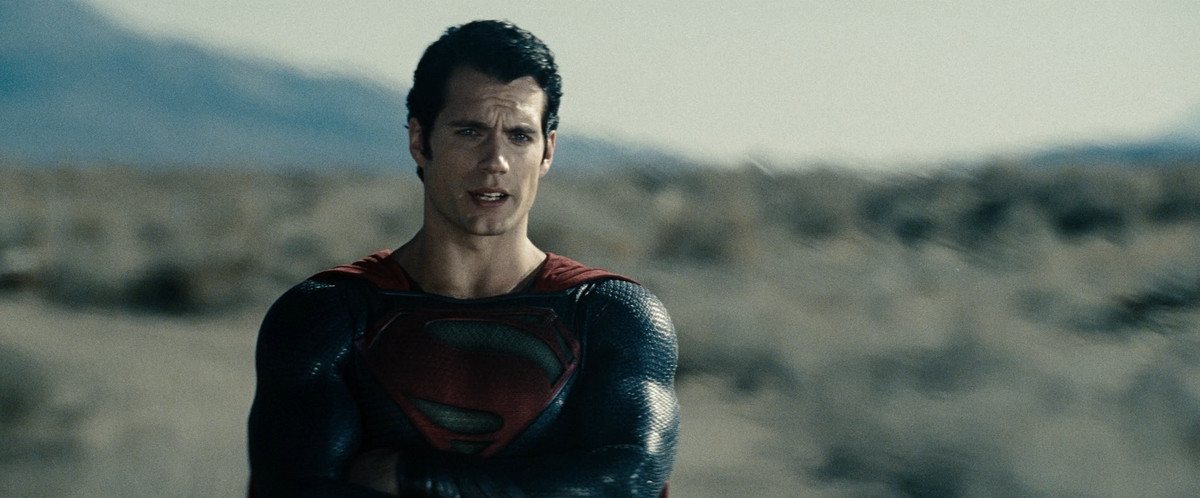 Henry Cavill crosses his arms while talking with a furrowed brow in Man of Steel.