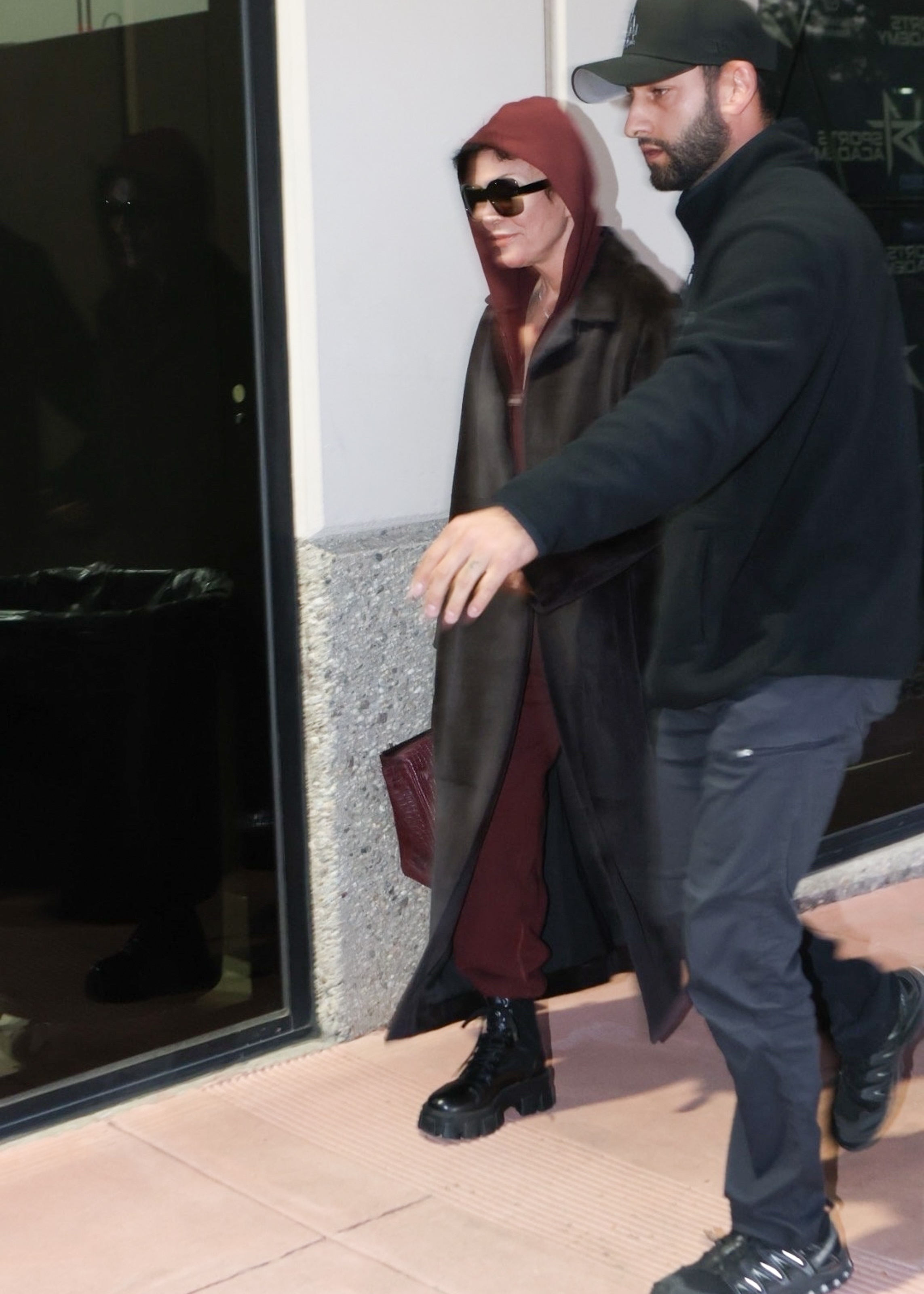 Kris wore a burgundy jumpsuit, fur coat, and boots, and carried a Birkin bag