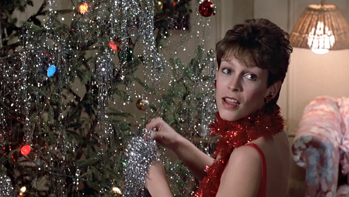 Jamie Lee Curtis puts tinsel on a Christmas tree in Trading Places