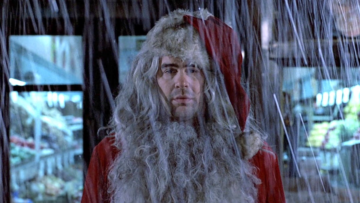 Dan Aykroyd sad in the rain wearing a dirty Santa suit in Trading Places