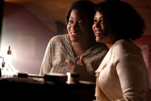 Two women smile as they into a mirror in "The Color Purple."