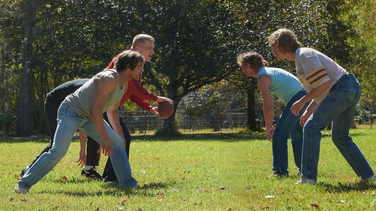 A family of men playing football in the backyard in The Iron Claw