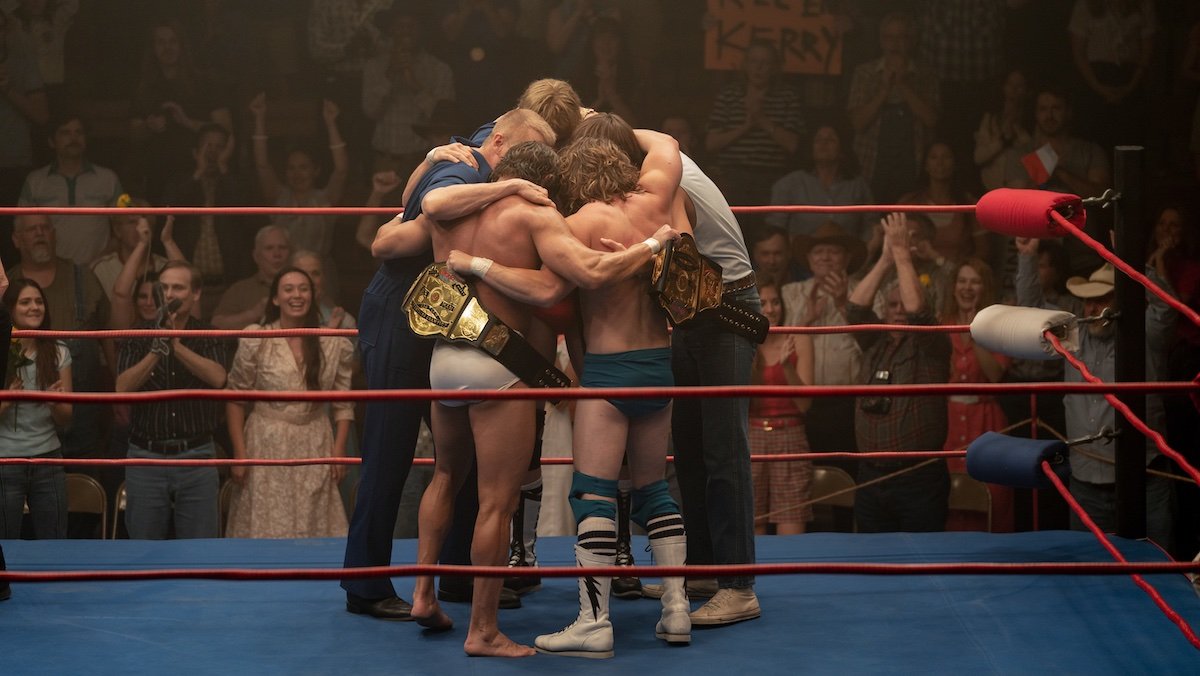 A group of men hug in the middle of the ring in The Iron Claw