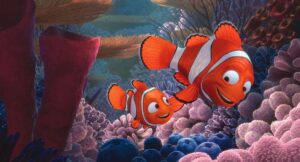 An adult clownfish swims with a smaller one in a scene from "Finding Nemo."