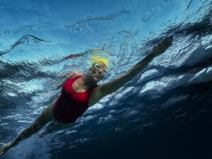 Seen from beneath the surface, Annette Bening swims in a scene from "Nyad."