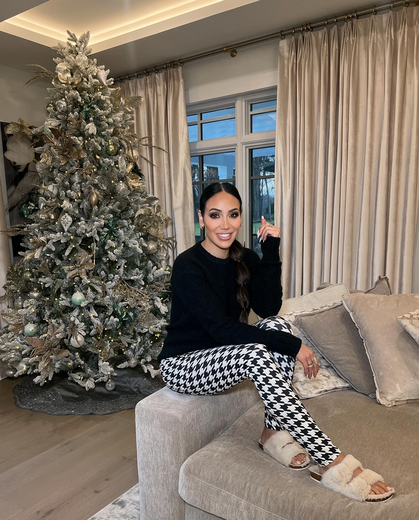 Melissa posed in front of her silver Christmas tree wearing cozy leggings
