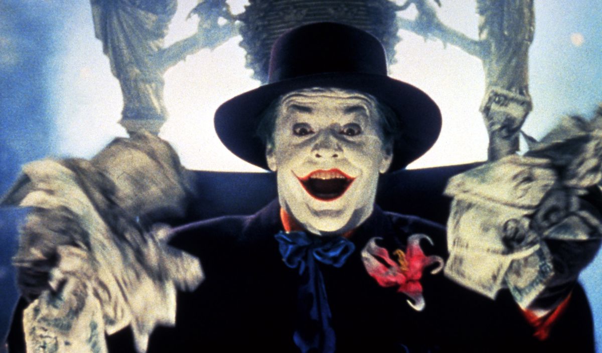 Jack Nicholson as Joker in 1989’s Batman, fists full of wads of money, mouth open in excitement