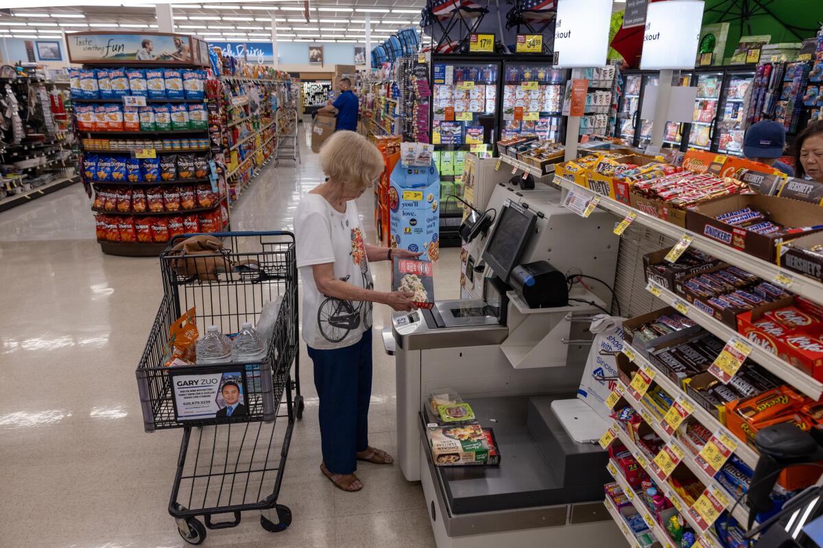 A woman uses a self-checkout system.