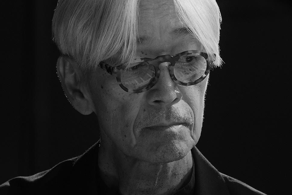 A black-and-white image of Ryuichi Sakamoto