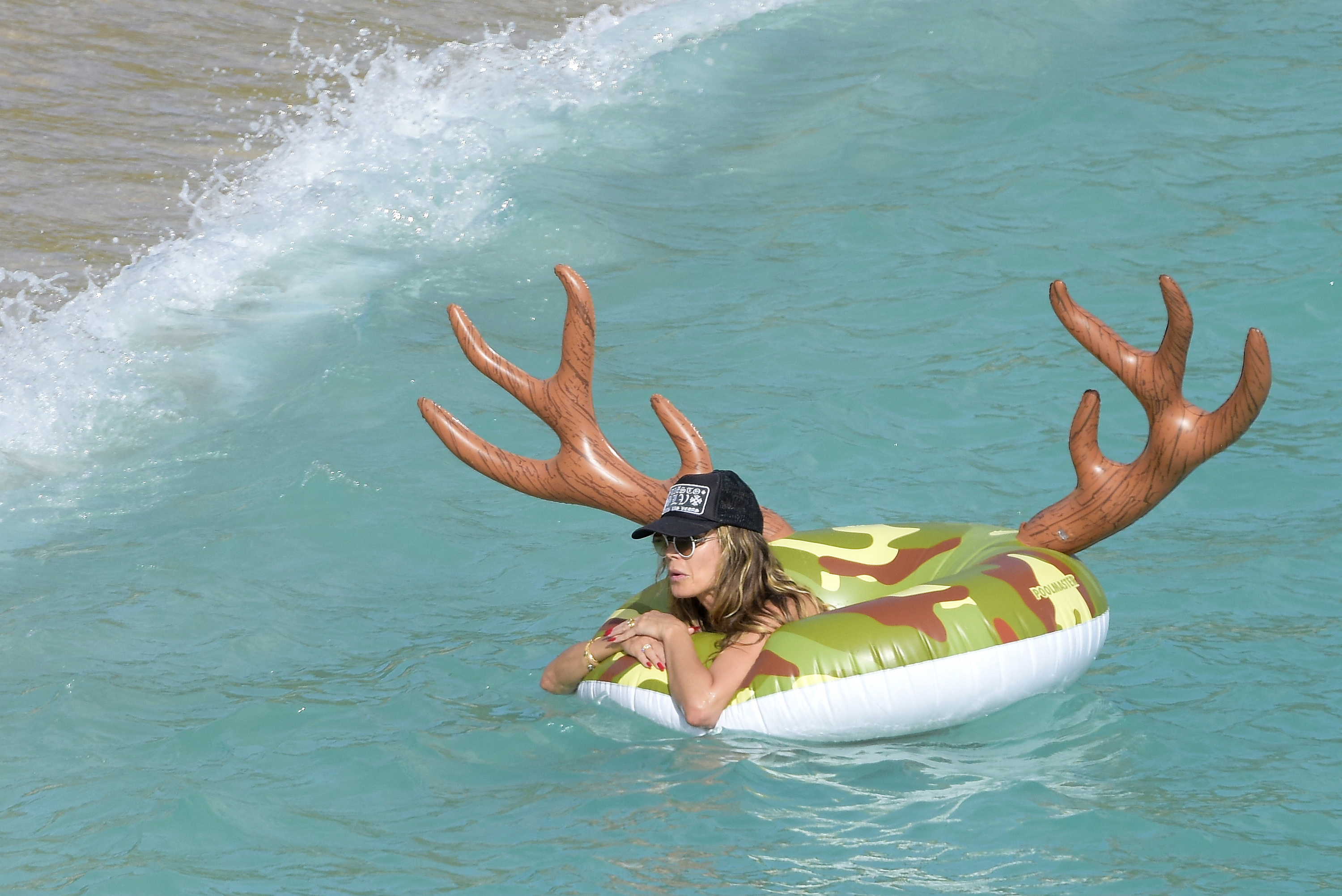 She swam in the water with a massive pool tube with antlers sticking out of it